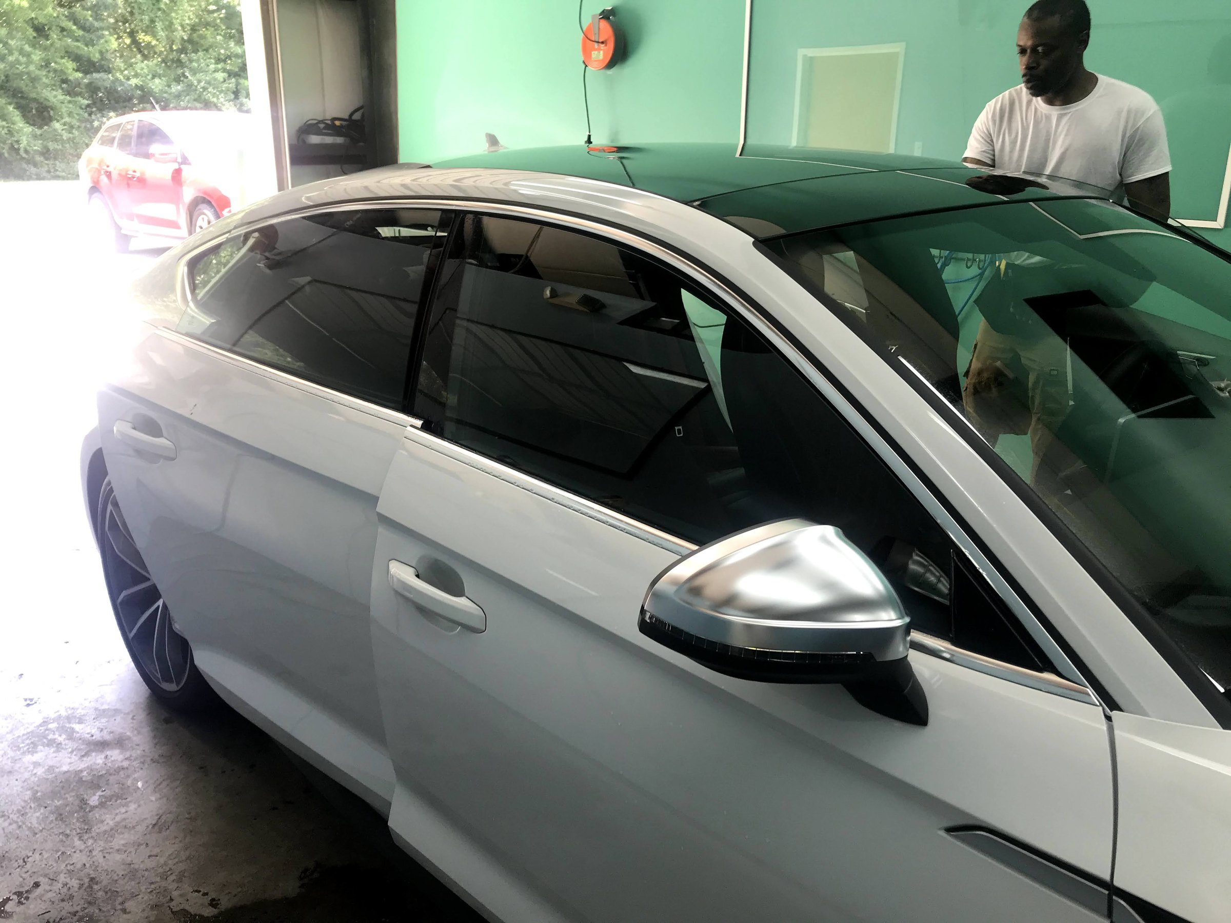 White Audi showing a large front windshield and professionally tinted side glass