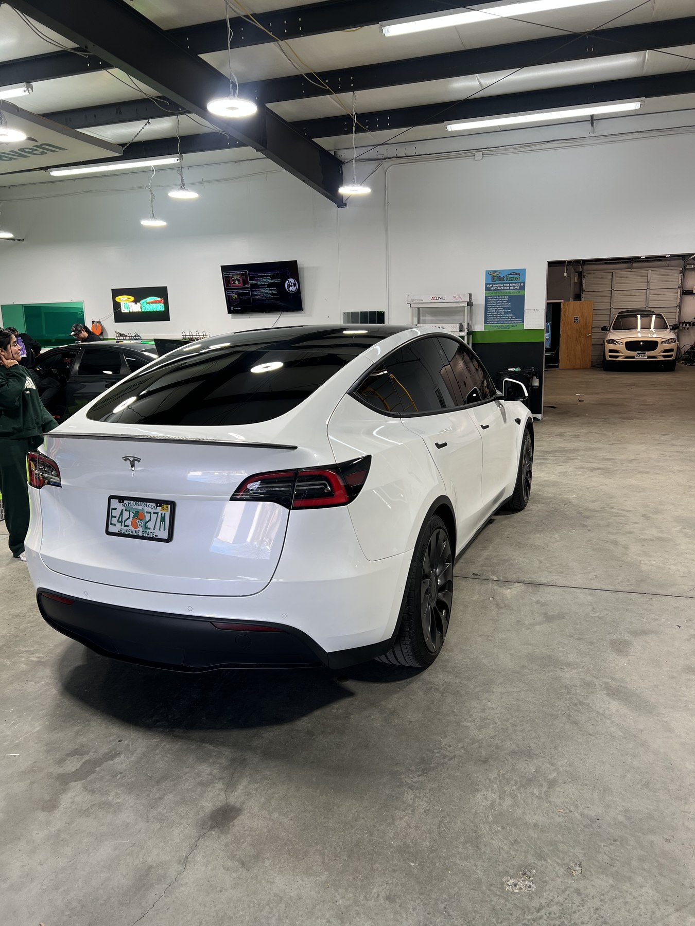 Rear three-quarter view of a white Tesla Model Y with professional window tint