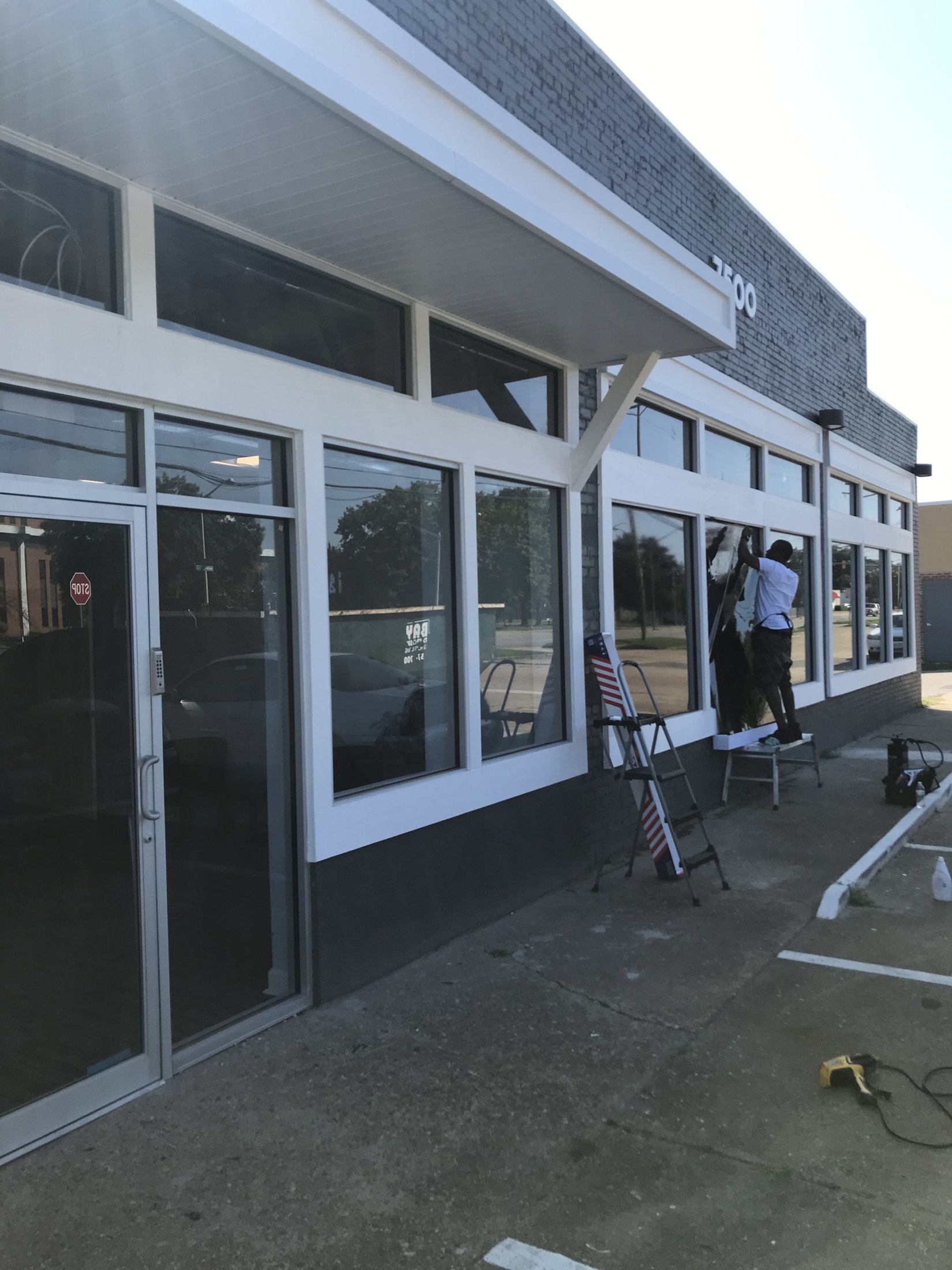 Tint Heaven installer applying commercial window film to storefront glass