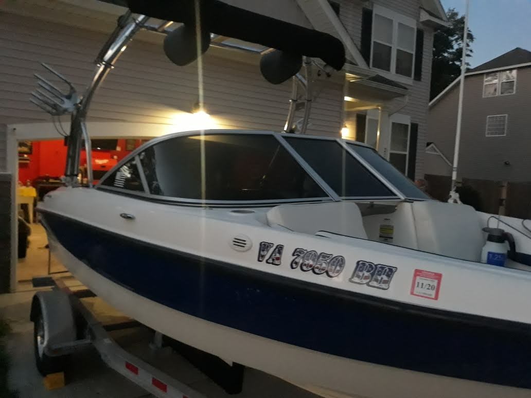 Blue and white boat with dark marine tint installed on its windshield