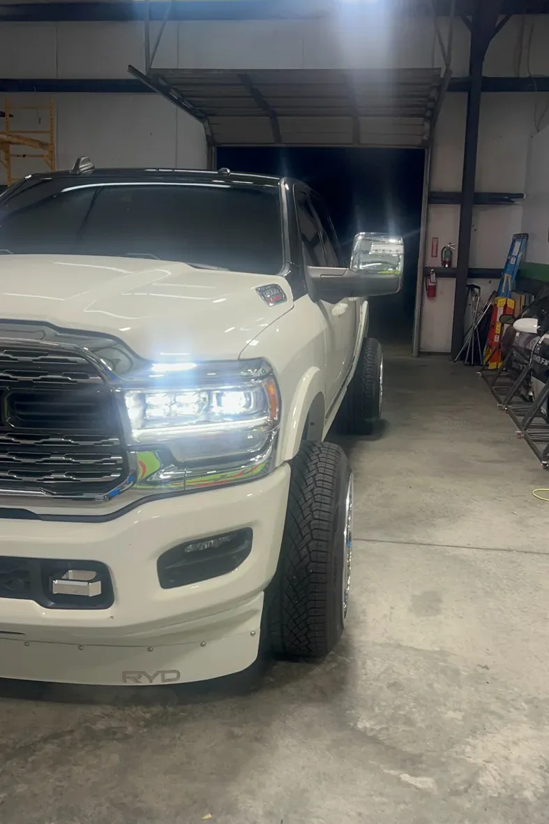 Front corner of white Ram 1500 showing dark roof and window treatment