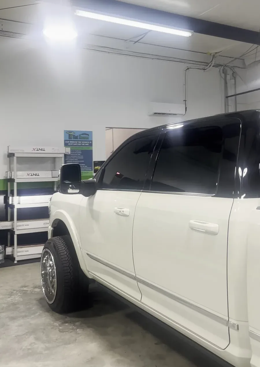 White Ram 1500 with dark upper cab and windows, viewed from the side