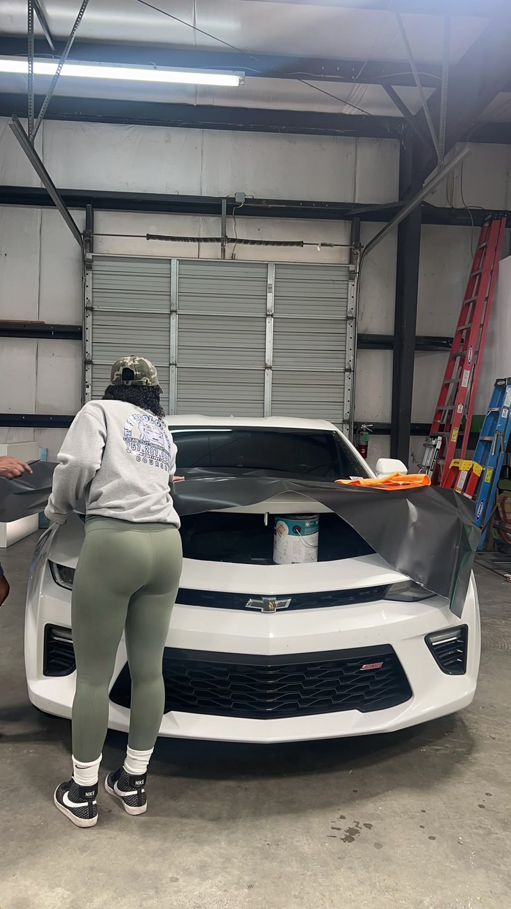 Tint Heaven technicians applying vinyl across a vehicle hood